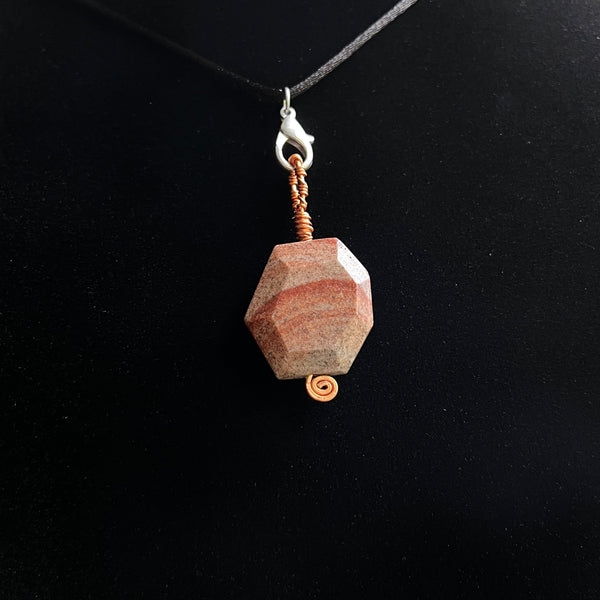 Faceted stone pendant on copper