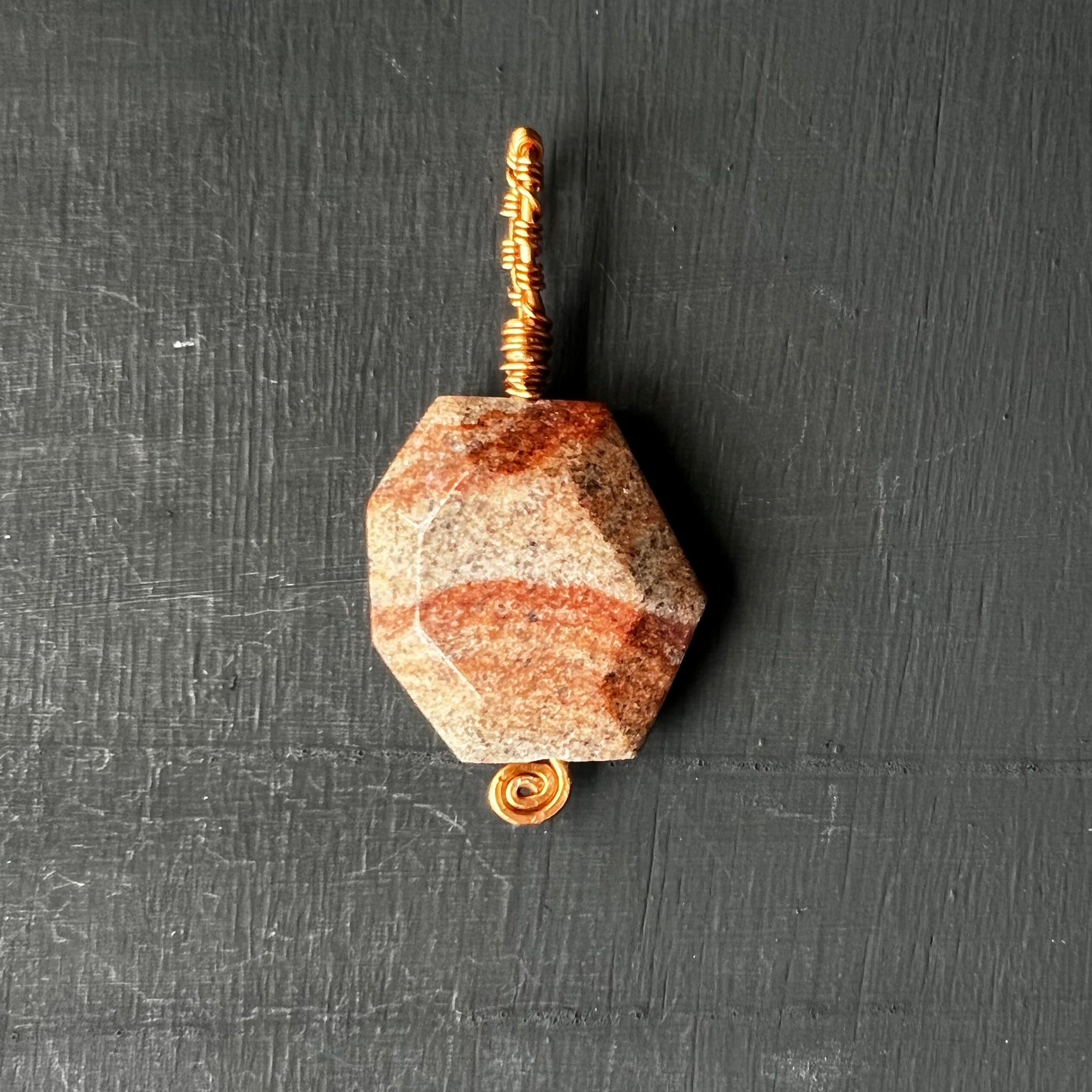 Faceted stone pendant on copper