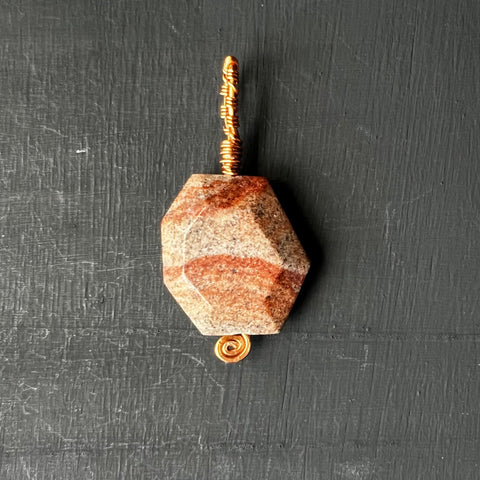 Faceted stone pendant on copper